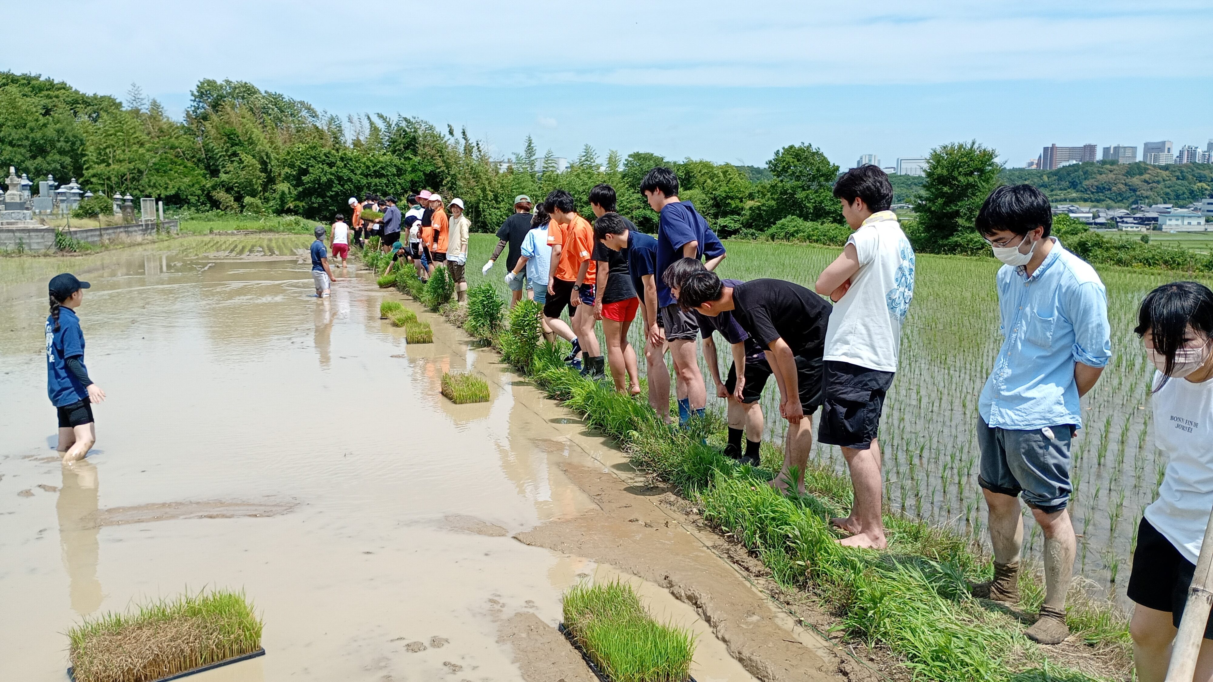 慣れない田植えの説明を神妙な趣で聞く学生達